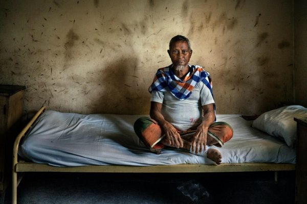 Bangladesh: hôpital DBLM de Nilphamari 4 Ein Patient sitzt auf seinem Bett im Lepra-Spital in Bangladesch