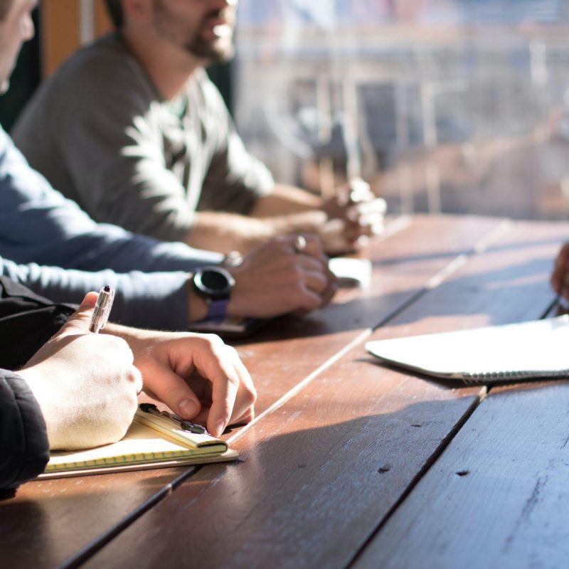 Menschen studieren Kursunterlagen an einem Tisch